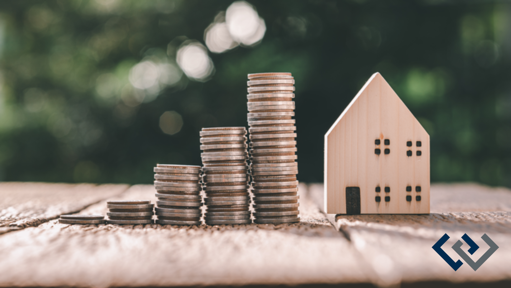 several piles of coins next to a small wooden model of a house