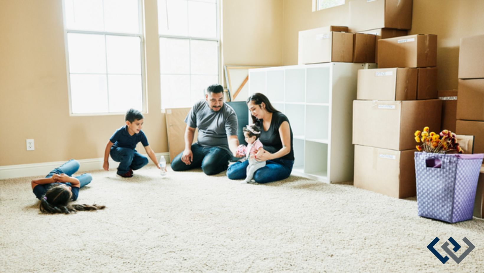 room in a home with moving boxes, two adults and three children