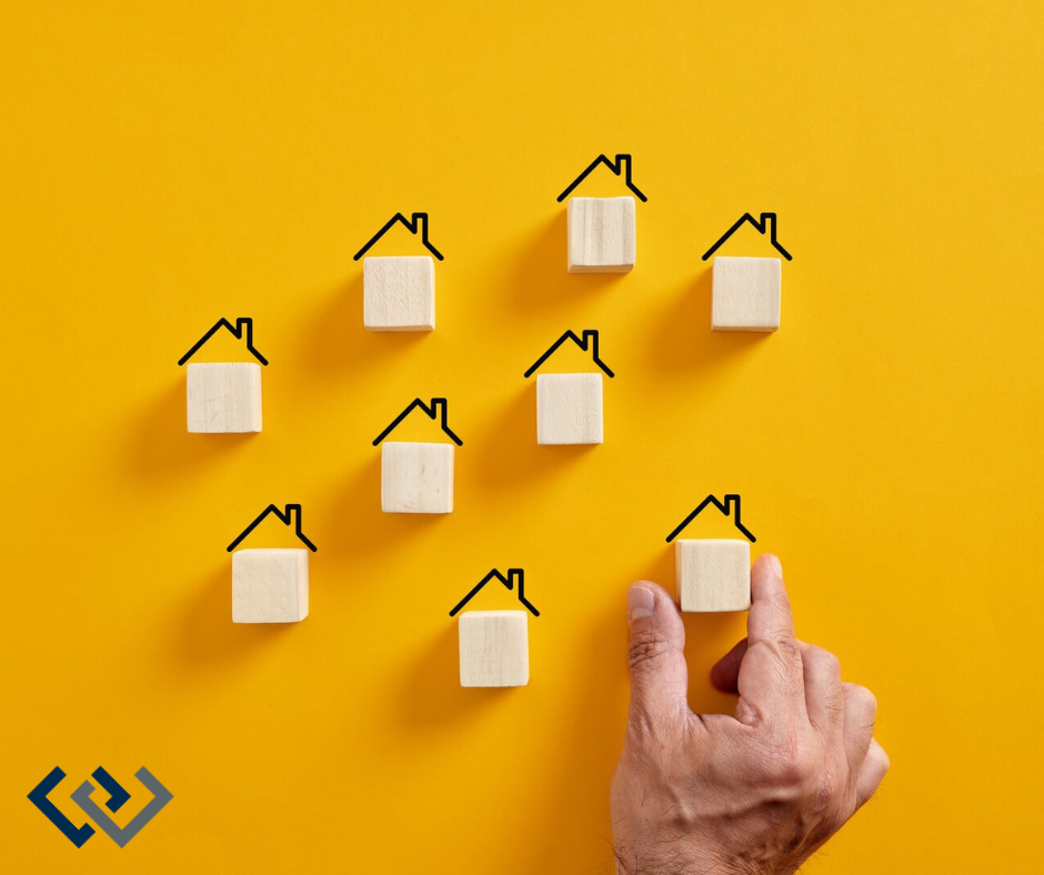 Little wooden blocks with "roofs," look like they are being placed by a big human hand