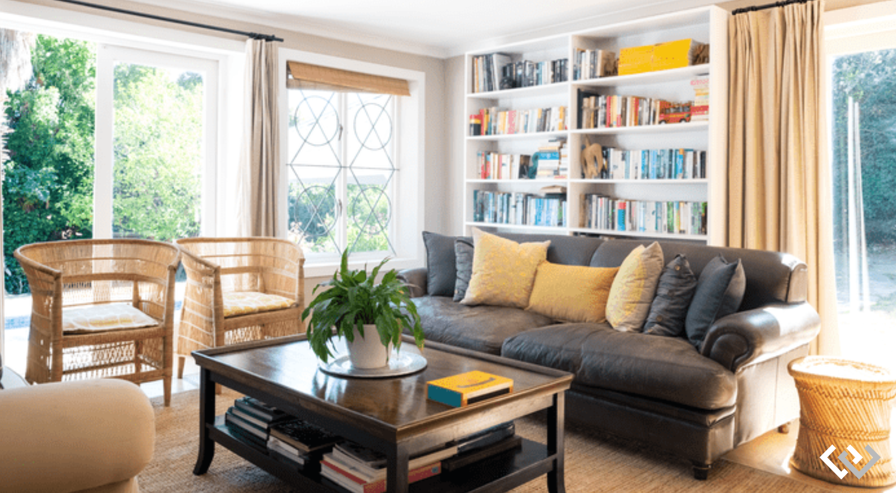 a living room with couch, coffee table, and bookshelves in the background