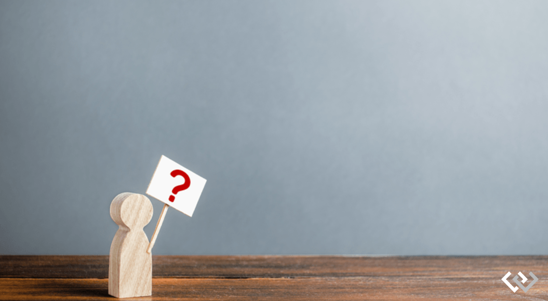 Little wooden figure, holding a sign with a question mark