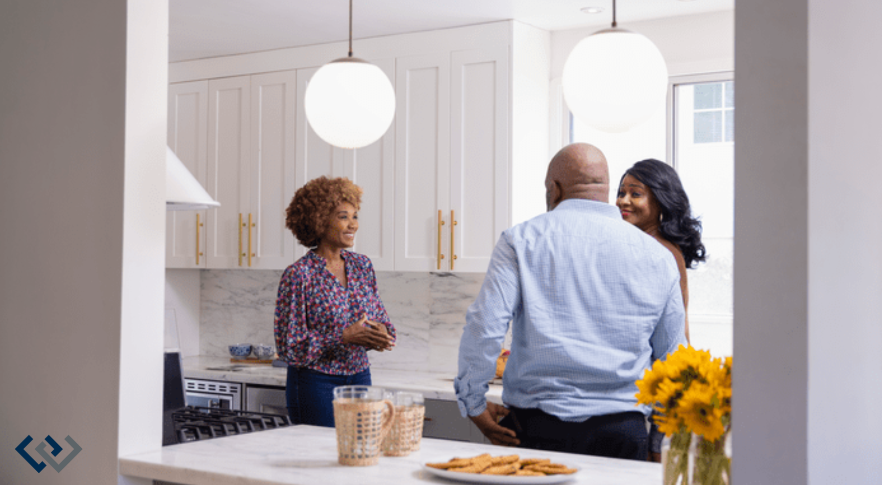 Three adults standing around a kitchen counter