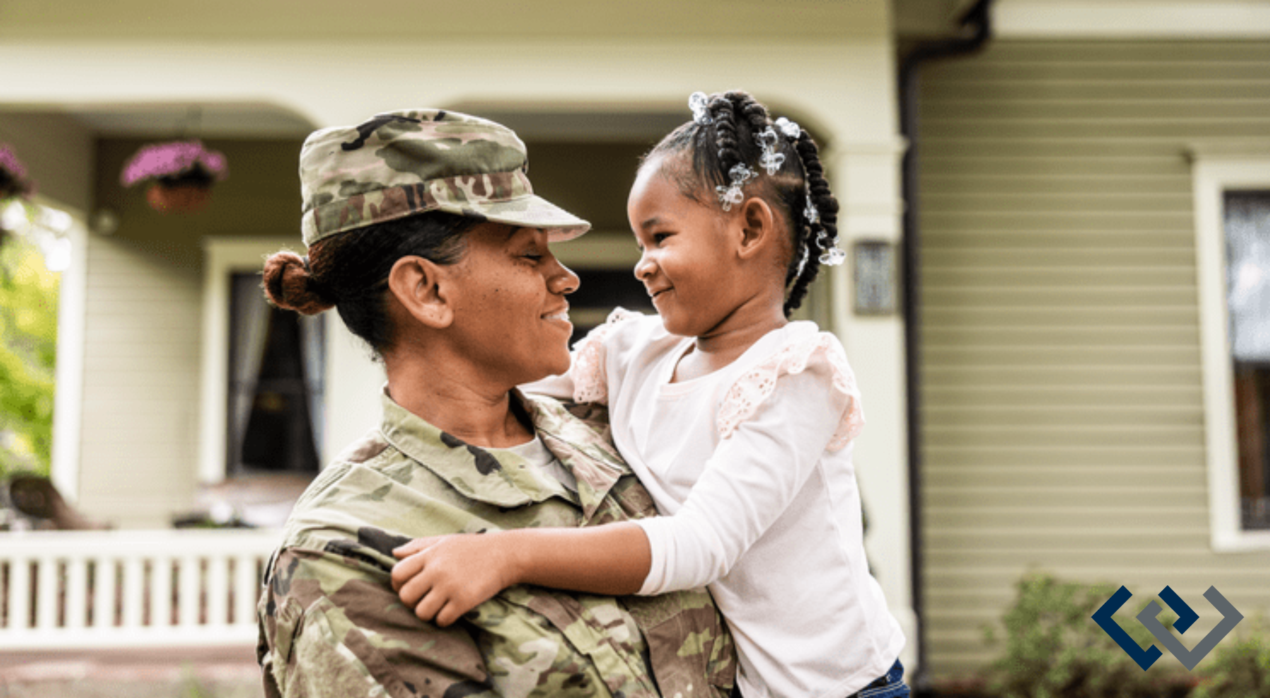 A female in military uniform, holding a young child - looking eye to eye